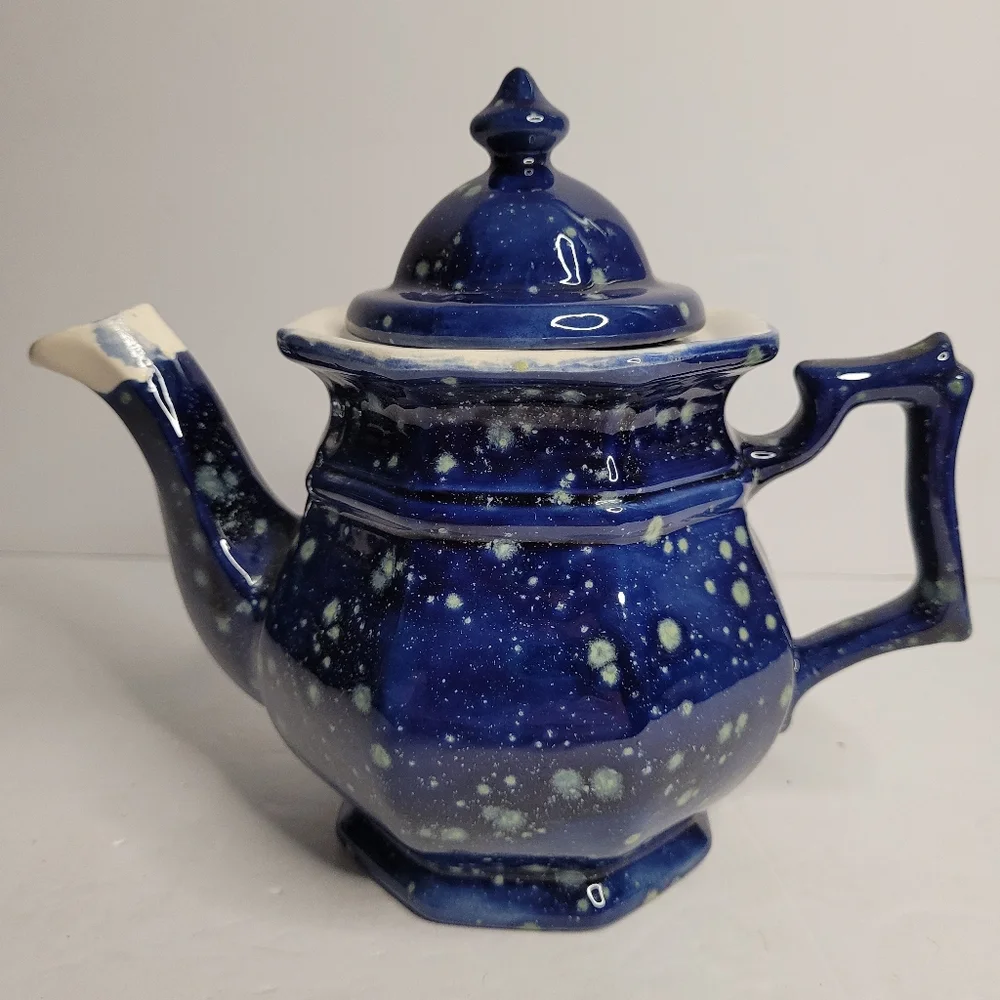 A blue and white speckled teapot. 271